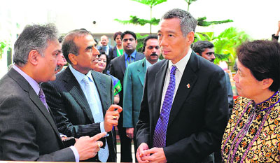 Singapore Prime Minister Lee Hsien Loong (3R) and his wife along with Bharti Airtel chairman & MD Sunil Bharti Mittal (2R) and CEO (India & S. Asia) Sanjay Kapoor during a demo of Airtel Money mobile funds transfer at the companys headquarters in Gurgaon on Thursday. Loong, who is leading a delegation, also met Haryana CM Bhupinder Singh Hooda and evinced interest in the industrial development of the area and future urbanisation projects. 