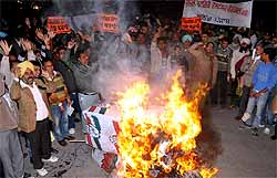 Members of the General Categories Welfare Federation burn effigies of the Congress and the BJP while demonstrating against caste-based reservation, in Bathinda on Thursday
