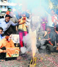 BJP workers celebrate the partys win in the Assembly poll by bursting crackers at the party headquarters in Ahmedabad on Thursday.
