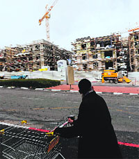 A man walks past a construction site in Gilo, a Jewish settlement that Israel erected on land in the West Bank, on Thursday