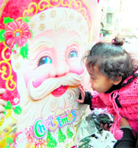 A kid showers his affection on Christmas special Santa Claus in Amritsar on Friday. 