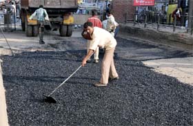 PRTC workers engaged in relaying the road near the entrance of the bus stand. The work resulted in traffic snarls on the main road as the buses were queued outside the entry point of the bus stand.