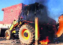 A JCB machine torched by residents of Sheetla Colony in Gurgaon on Friday