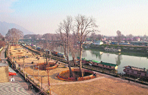 Residents bask in the sunshine at a park on the bank of the Jhelum in Srinagar on Friday. 