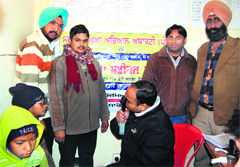 Doctor examines schoolchildren during an eye check-up camp at satellite hospital in Amritsar on Saturday.