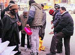 People warm themselves by a bonfire in Srinagar on Saturday