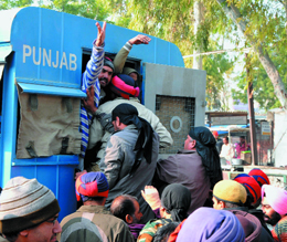 Members of the Unaided Staff of Aided Schools Front being bundled into a police van after they protested against the government on the road in Bathinda on Sunday.