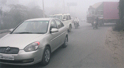 Vehicles move at a snails pace in dense fog on the Rohtak-Delhi Highway on Sunday morning.
