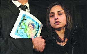 Lisha, standing with her father Benedict Barboza, looks towards a picture of her late mother, nurse Jacintha Saldanha, in this file photo.