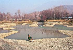 A man enjoys hookah on the banks of the Sindh river in central Kashmirs Ganderbal district