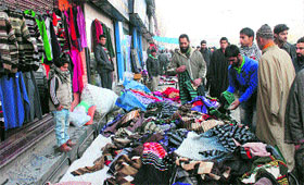 People sift through woollens on sale at a street market in Srinagar on Sunday.