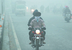Commuters brave the fog in Bathinda on Monday morning. Tribune photo: Pawan Sharma