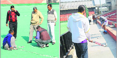 Groundsmen mark the ground for a hockey match after its scheduled time; and (right) payers wait for the match to begin on Monday.