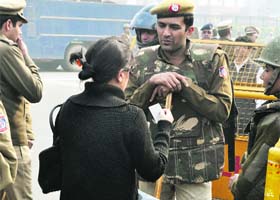 A girl shows her ID to a policeman to enter the restricted area near Rajpath in New Delhi on Monday