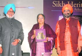 Gursharan Kaur, wife of PM Manmohan Singh, releases a book Sikh Heritage: Ethos & Relics by Sikandar Singh (L) and Roopinder Singh (R) in New Delhi on Monday