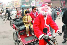 Riding with Santa: A man dressed as Santa Claus takes kids for a joyride on a rickshaw near Fire Brigade chowk in Bathinda on Christmas