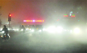 Thick fog engulfs road traffic in New Delhi on Tuesday night.