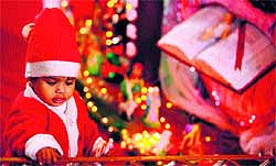 A child dressed as Santa Claus plays at a church during the Christmas celebrations in Jammu on Tuesday