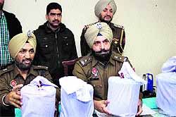 Policemen show the opium seized from five smugglers in Jalandhar on Tuesday