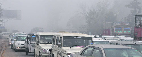 Vehicles move at a snail's pace due to dense fog in Ludhiana on Tuesday.