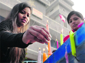 Girls light candles at a church on Christmas in Ludhiana on Tuesday.