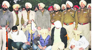 Policemen with arrested gangsters at Amritsars Mattewal village on Tuesday.