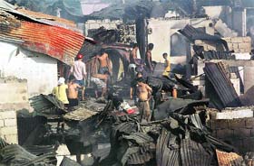 Residents return to their charred homes after fire razed some 500 houses at a residential area in San Juan City, Manila, on Tuesday