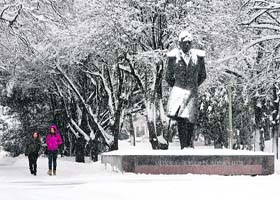Two women walk during a snowfall as the temperature dipped to -8 degree Celsius in Russia's southern city of Stavropol on Tuesday