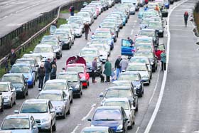 Motorists stand next to their cars in a traffic jam after a fatal crash caused the M6 motorway to be closed near Stoke-on-Trent, Britain, on Tuesda