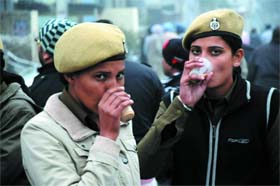 Policewomen sip tea to beat the chill in Bathinda on Wednesday