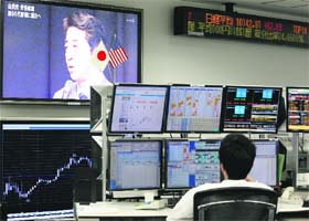 A TV set at a forex trading firm shows Japan's incoming PM Shinzo Abe speaking in Tokyo on Wednesday