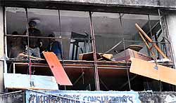 Workers remove glazing at an SCO in Sector 17 during an anti-encroachment drive of the Estate Office in Chandigarh on Wednesday