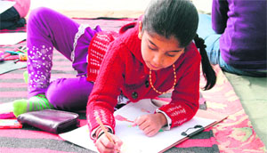 A young girl engrossed in painting during a competition held in Dehradun on Wednesday. 