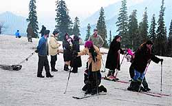 Tourists ski on the slopes of Gulmarg