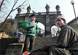 A vendor sells grams in front of Hazrat Sheikh Hamza Makhdoom Sahib shrine in Srinagar on Wednesday