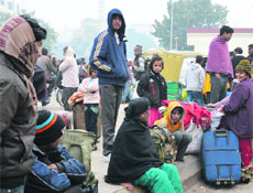 Passengers wait for a train at the Ludhiana railway station. 