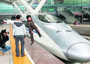 Passengers in front of the longest high-speed rail route (2,298 km) between Beijing and Guangzhou which would cut the travel time from over 20 hours to eight hours in Guangzhou, China, on Wednesday.