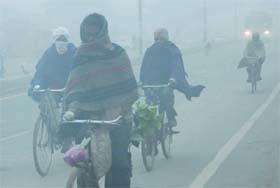 Commuters pedal their way through dense fog in Bathinda