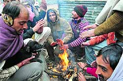 With the mercury nosediving in the region, labourers sit around a bonfire to keep themselves warm in Gurgaon on Thursday