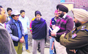 Policemen question people at Rishi Nagar where unidentified assilants hacked a middle-aged couple to death. 