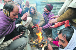 People light a bonfire in Jammu on Thursday. 