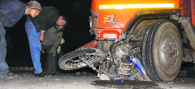 A motorcycle lies crushed under a truck; and (below) two of the five cars that were damaged after being hit by the truck at the railway light point in Chandigarh on Friday.