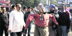 Rashtravadi Swabhimani Punjabi Morcha members burn effigy of Uttarakhand Raksha Morcha president and former minister TPS Rawat at Clock Tower in Dehradun on Friday.