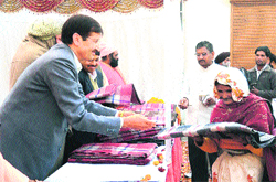 Chief Development Officer VS Dhanik distributes blankets to the poor at a function in Haridwar on Friday.