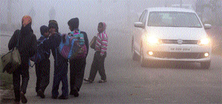 Schoolchildren brave the chill in Karnal on Friday. 