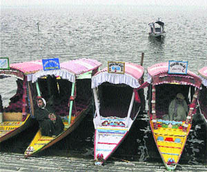 Shikarawalas wait for customers at Dal Lake on a cold day in Srinagar. 