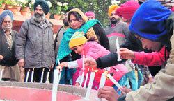 Children assisted by their parents light up candles to pay tributes to the Delhi gang rape victim at Jallianwala Bagh in Amritsar on Saturday. photo: sameer sehgal