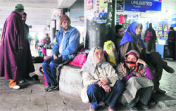 Passengers wait at the General Bus Stand after the Jammu-Srinagar National Highway was closed on Saturday. Tribune photo: Inderjeet Singh