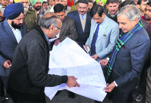 Railway Minister Pawan Kumar Bansal looks at a design of the upgraded Chandigarh Railway Station on Saturday. 