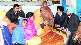 Cabinet minister Surjit Singh Rakhra with the family of the victim at Badshahpur village on Saturday. 